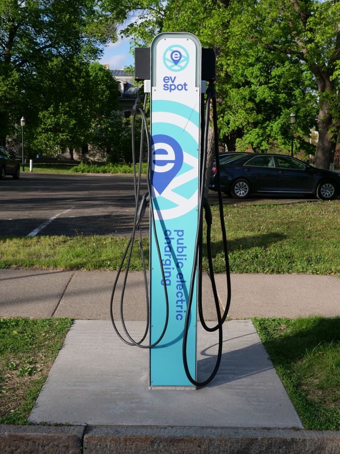 A public EV charging station located outdoors in a city park during the daytime.